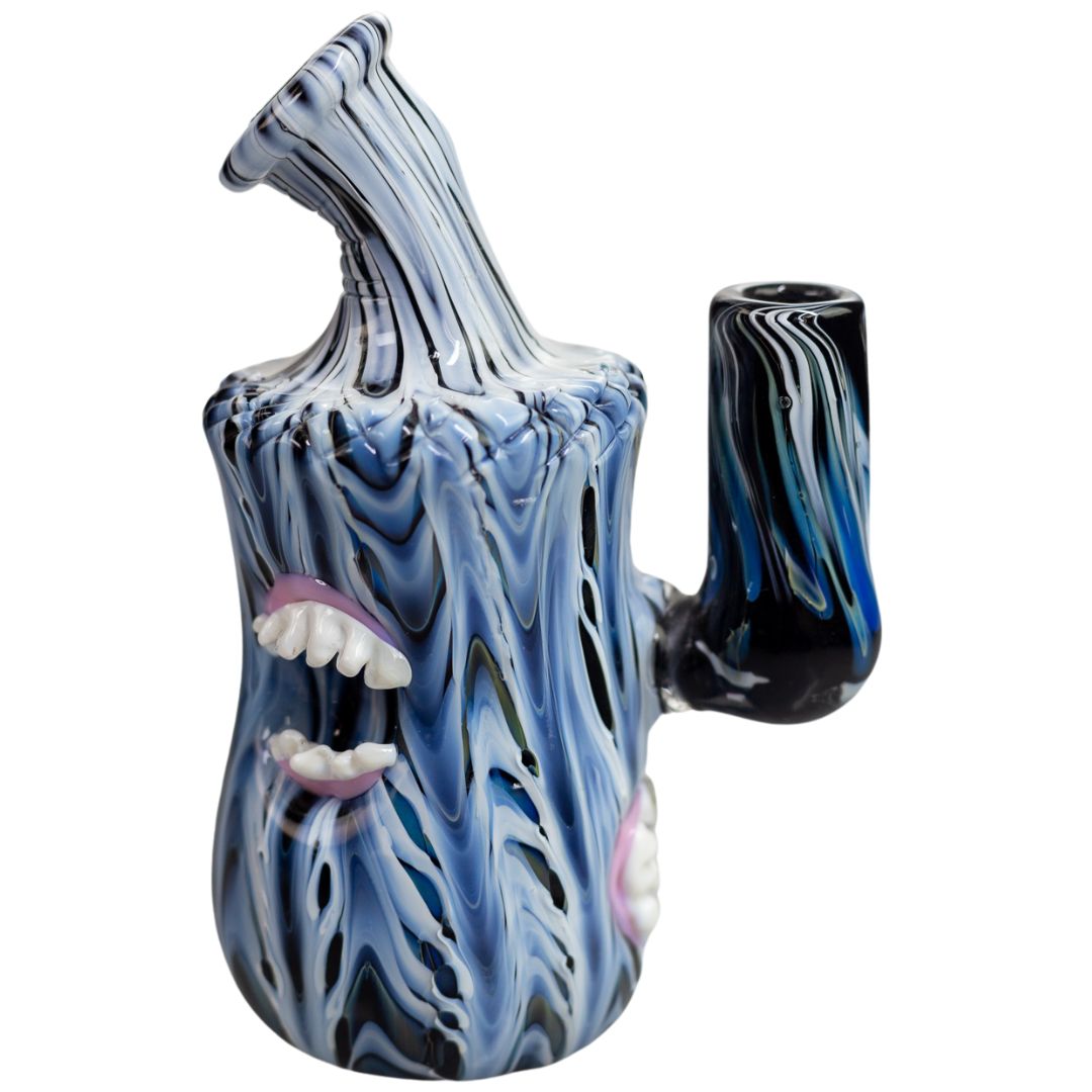 Side view of a Pebbled Sculpted rig with a melted baby blue, black and white design. This piece is embellished with glass mouths. - Up N Smoke.