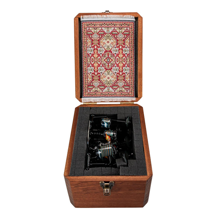 "Open wooden storage box that contains a decorative rug placemat and an AJ Roberts Wig Wag Drum Set on a white background," - Up N Smoke.