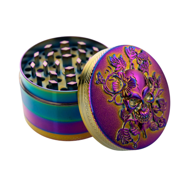 "Anodized 4-Piece Skull Grinder with its top compartment leaning against the rest of the product, showcasing the skull and foliage design," - Up N Smoke.