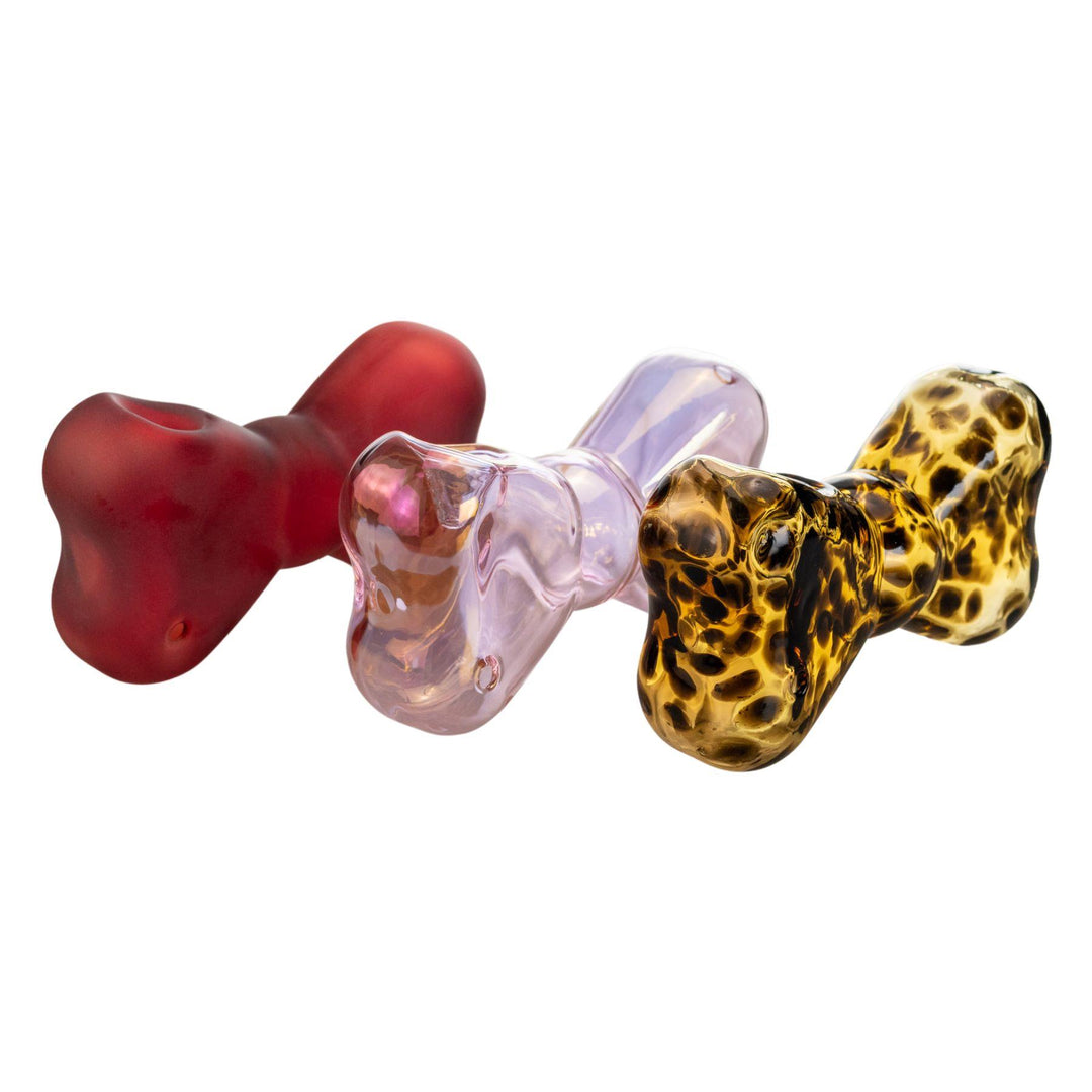 "Set of three bow-shaped glass hand pipes in Blush (iridescent pink), Leopard (tortoise-shell pattern), and Ruby (matte red), showcasing unique color variations and stylish design."