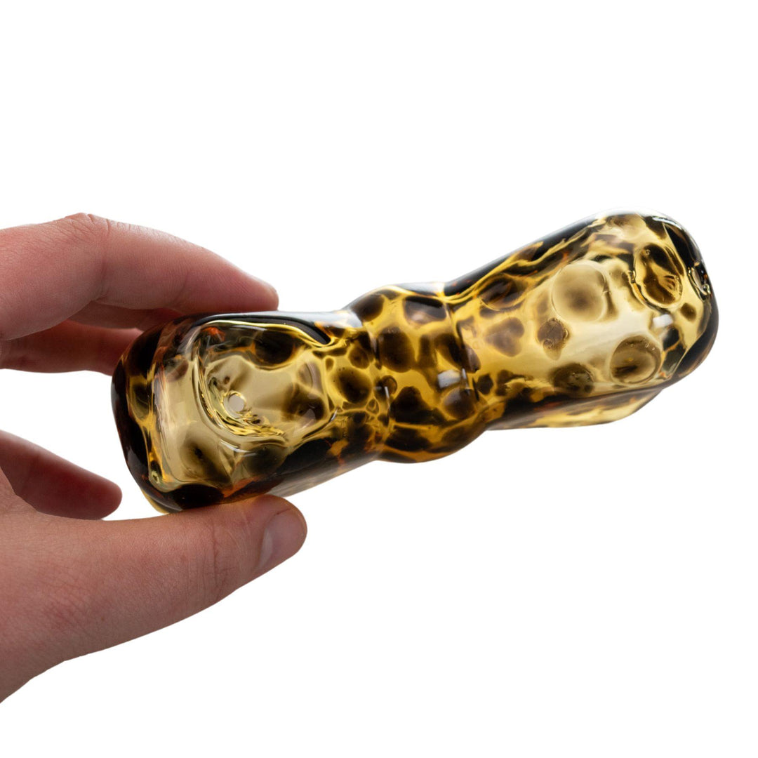 "Tortoise-shell patterned glass hand pipe shaped like a bow, featuring a classic leopard print design. This hand pipe was designed by Go Easy, a queer and woman-owned business based out of Texas." - Up N Smoke.