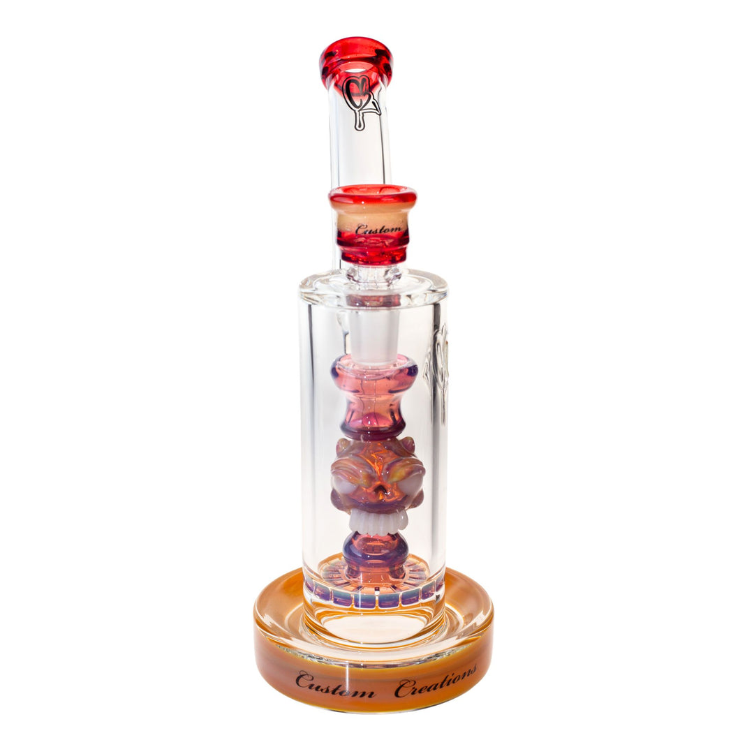 Frontal view of a C2 50mm Bubbler. This piece features a ratchet filter, an ornate down stem, and a recessive joint. The colors are hues of orange, purple, and red. - Up N Smoke.