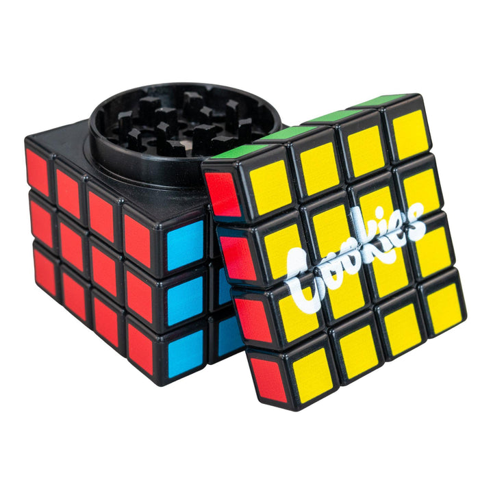 "Cookies Rubik's Cube Grinder with its lid leaned up against the rest of the item on a white background," - Up N Smoke. 