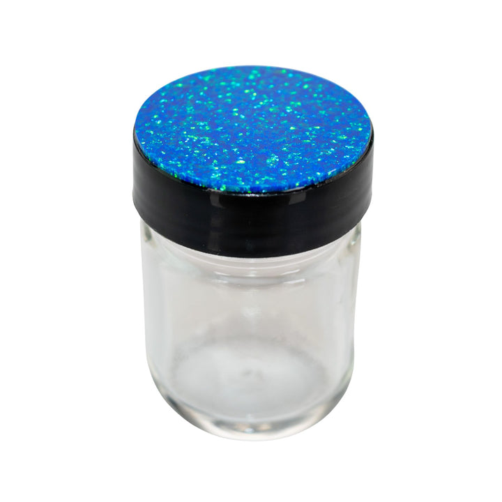 "Clear glass jar with a blue glittery lid on a white background," - Up N Smoke.