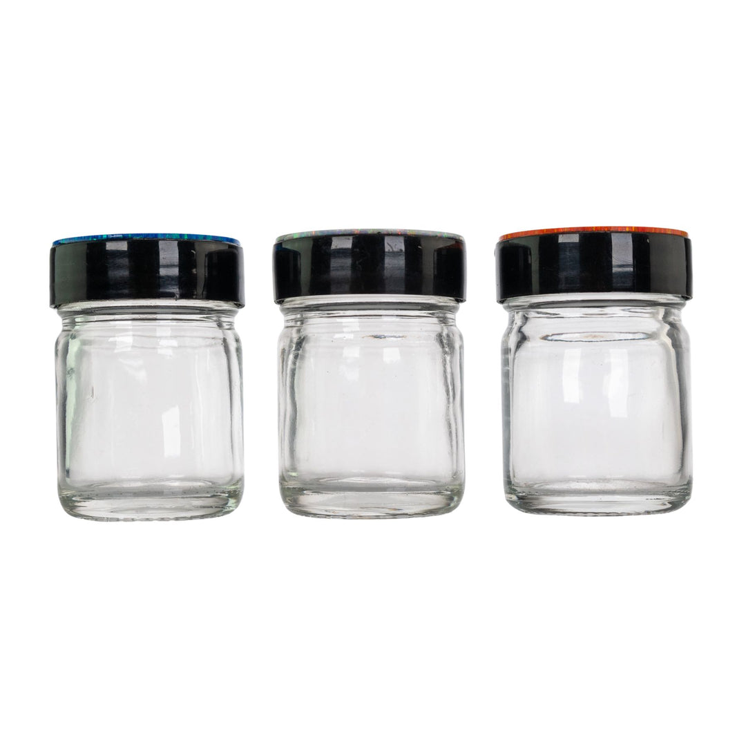 "Three clear glass jars with black lids on a white background," - Up N Smoke.