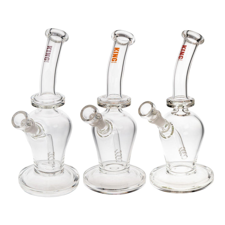 "Group of three King Volcano 50mmx10in Fixed Flare Bubblers in the colors purple, orange, and red, on a white background," - Up N Smoke.