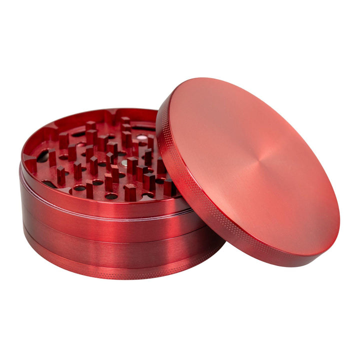 "Large Red 4-Piece Grinder with its lid propped up against the rest of the piece on a white background," - Up N Smoke.