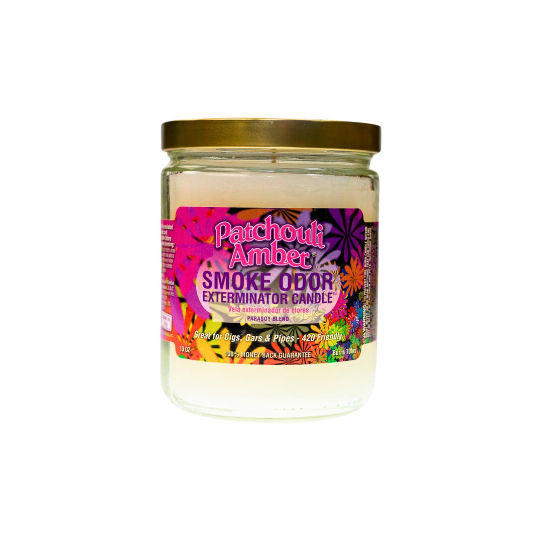 "Close-up of the Patchouli Amber Smoke Odor Exterminator Candle. The jar features a label adorned with colorful flowers. The candle inside has a creamy, neutral-colored wax, and the label highlights its sophisticated fragrance blend of patchouli and amber, designed to effectively neutralize smoke and other odors." - Up N Smoke.