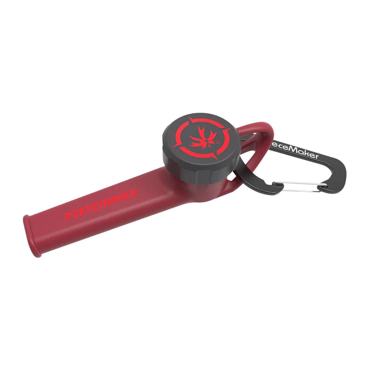 "A red Piecemaker 'Karma Go!' Silicone Travel Pipe that comes with a carabiner and a bowl cover," - Up N Smoke.