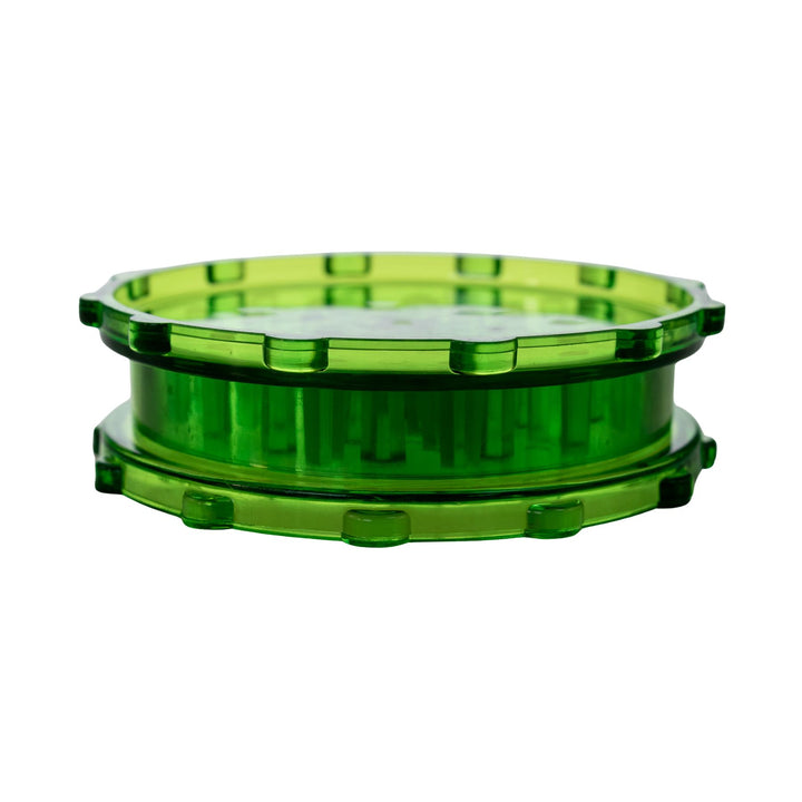 "Closed green plastic 2-piece grinder on a white background," - Up N Smoke.