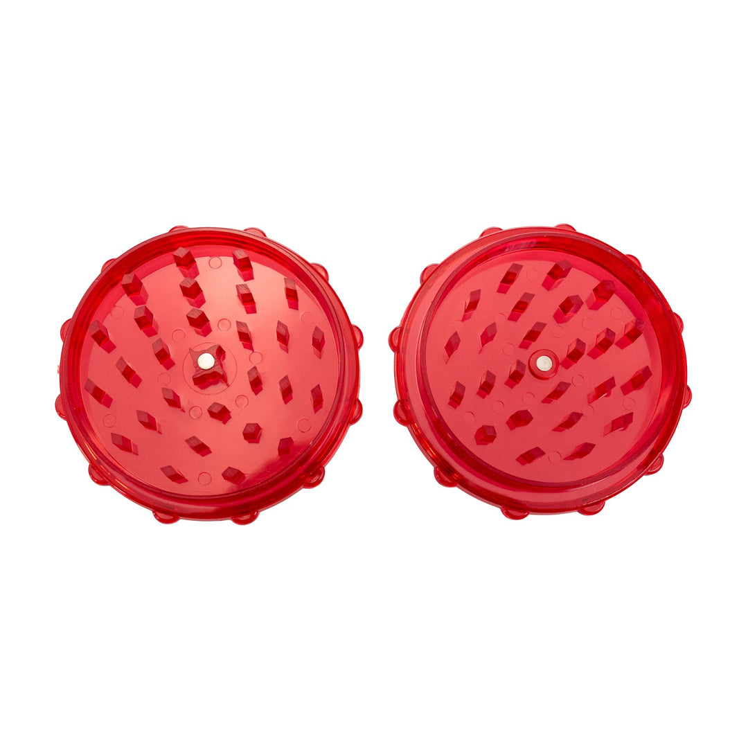 "Top-down view of a red plastic two-piece grinder on a white background," - Up N Smoke.