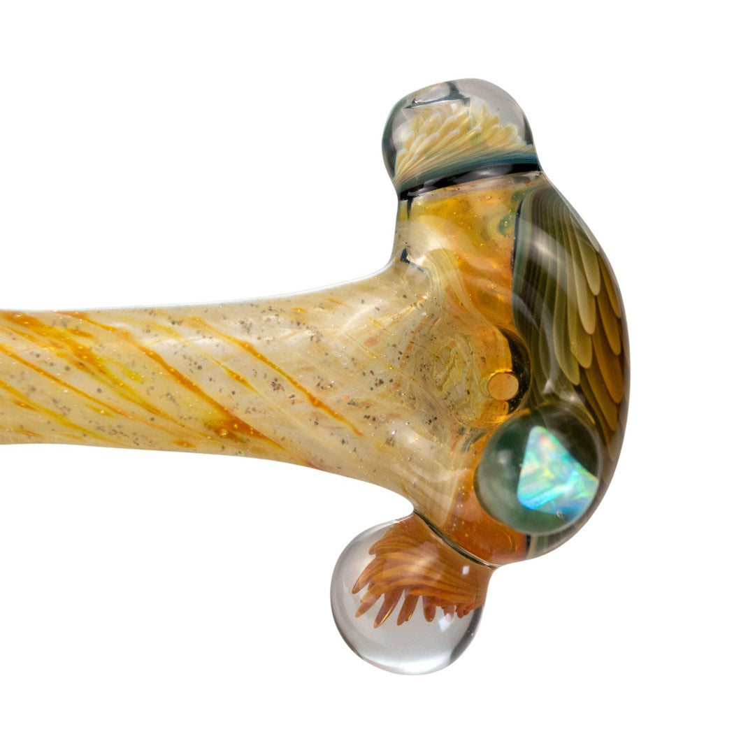 "Close-up of a gold-fumed glass pipe with a sparkling opal on the bowl and intricate swirl designs." - Up N Smoke.