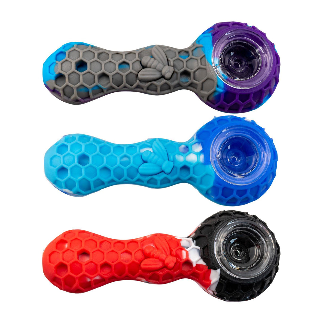 "A group of three multicolor Silicone Bee Pipes. This piece is embossed with a honeycomb design with a bee on the bodice," - Up N Smoke.