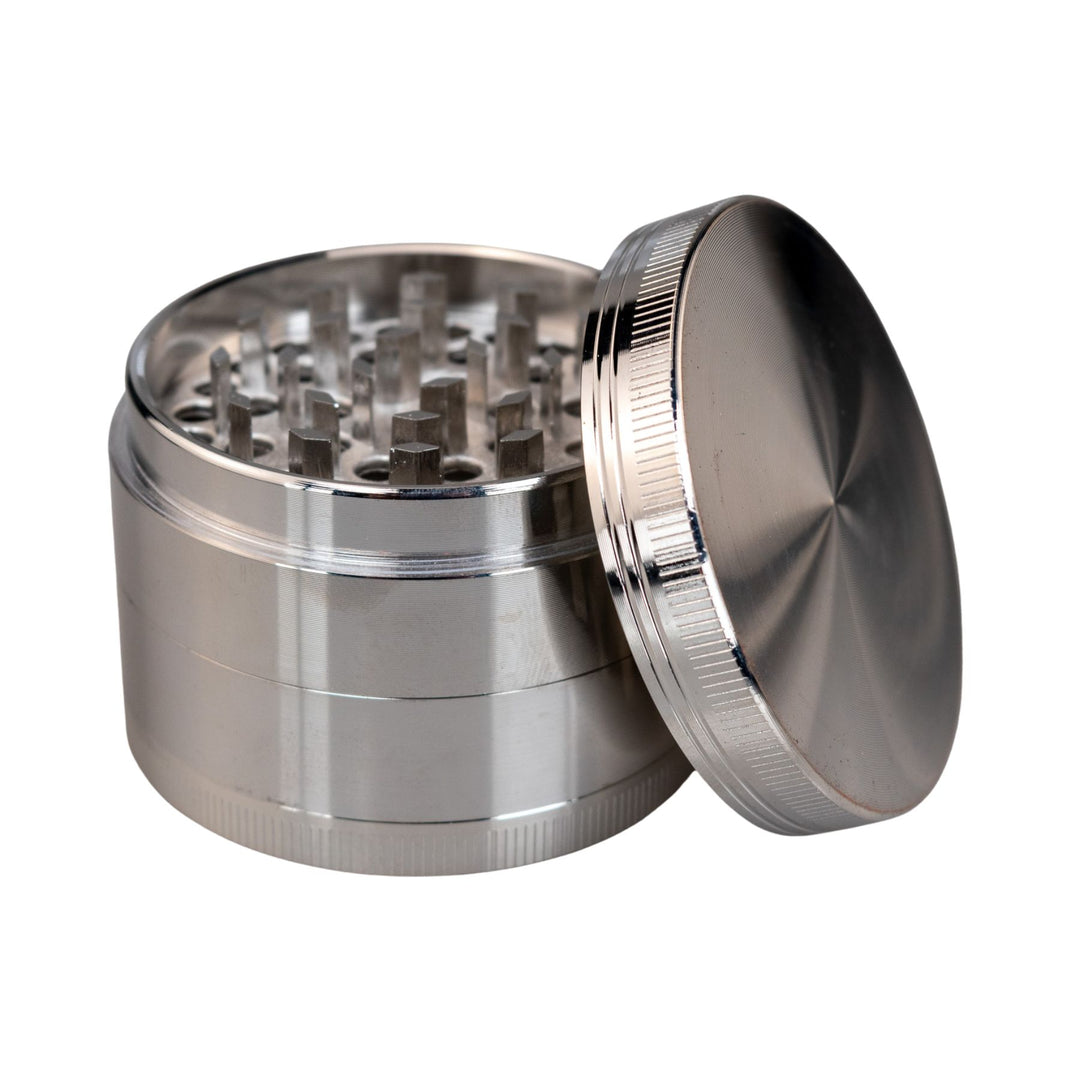 "Silver Classic 4-Piece Grinder with its lid propped up against the rest of the tool," - Up N Smoke.