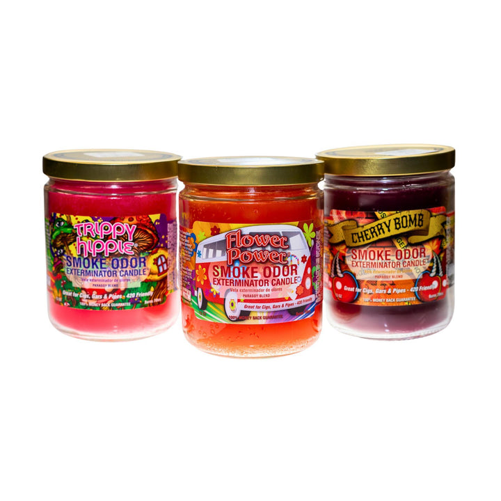 "Group photo of various Smoke Odor Exterminator candles displayed together. The candles come in different scents and colors, with each jar featuring a distinct label and design. The candles are arranged neatly to showcase their variety and packaging." - Up N Smoke.