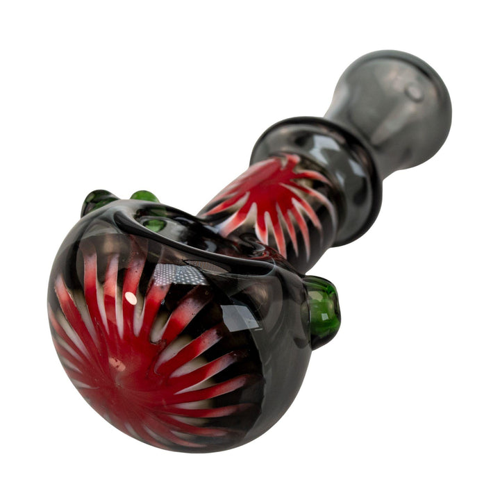 "Close-up of the red and white sunburst design on the front of a Step Into Now Pulsar herb spoon," - Up N Smoke.