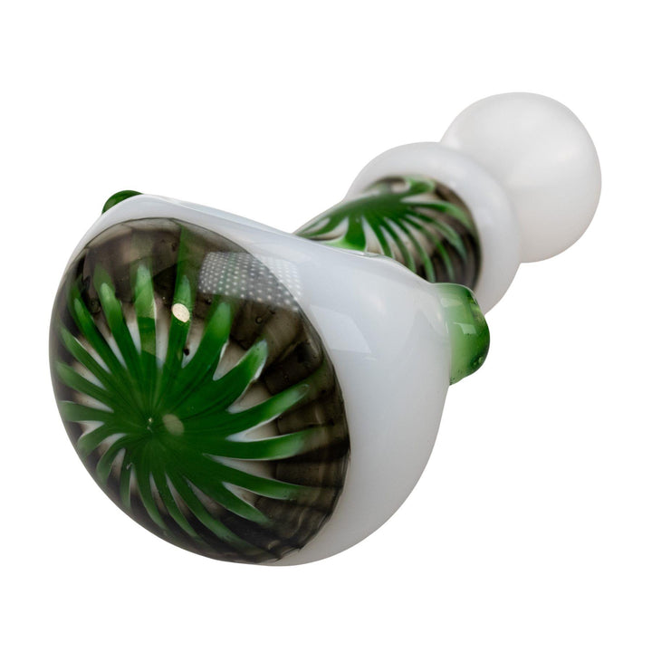 "Close-up of a green and black sunburst design on a white Step Into Now Pulsar Herb Spoon," - Up N Smoke.