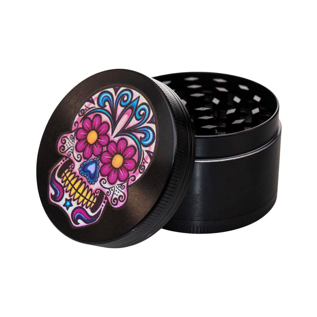 "Sugar Skull 4-Piece Grinder with the lid leaned up against the rest of the tool on a white background," - Up N Smoke.