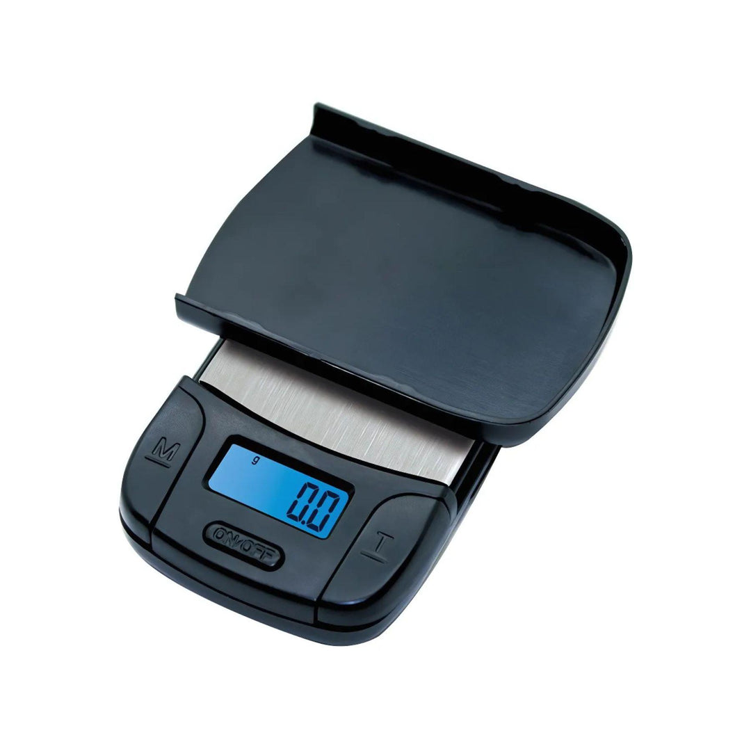 "Studio photograph of a US-Majestic 100g x 0.01g Digital Pocket Scale by US Balance. The lid is flipped upside down on top of the stainless steel scale to showcase how it can also be utilized as a tray for weighing items." - Up N Smoke.