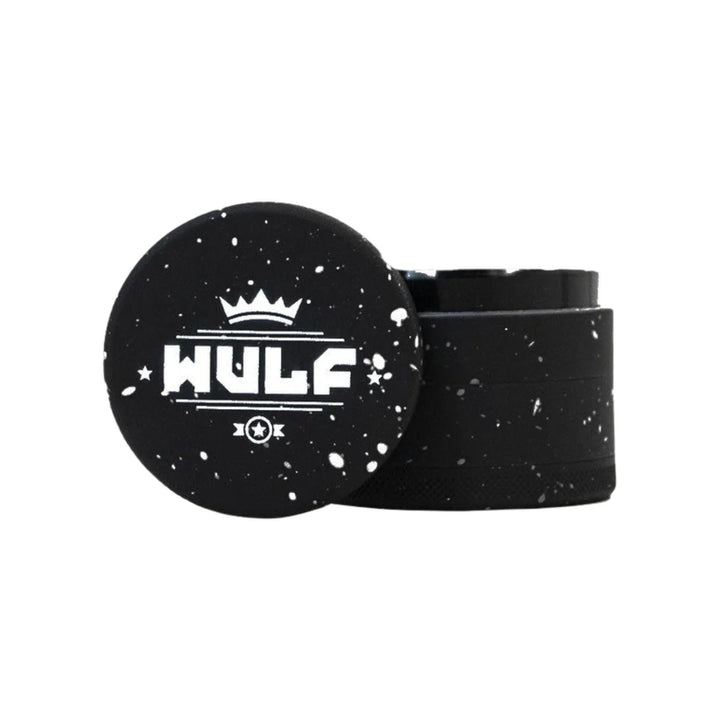 "50mm WULF 4-Piece Grinder that is black with a white splatter design," - Up N Smoke.