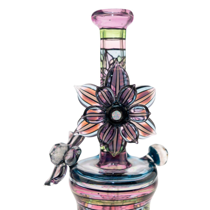 "Close-up of a Windstar x Mars Heady Collab, showcasing the rotating opal flower on a white background," - Up N Smoke.
