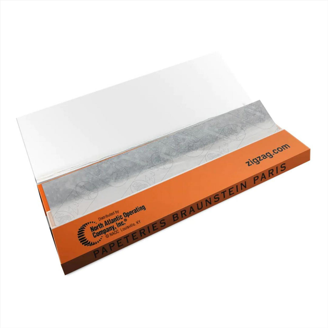 "Booklet of Zig Zag French Orange 1 1/4 Rolling Papers, known for their even and slow burn, providing a superior smoking experience. Made in France. This booklet is open to show the dispenser." - Up N Smoke.