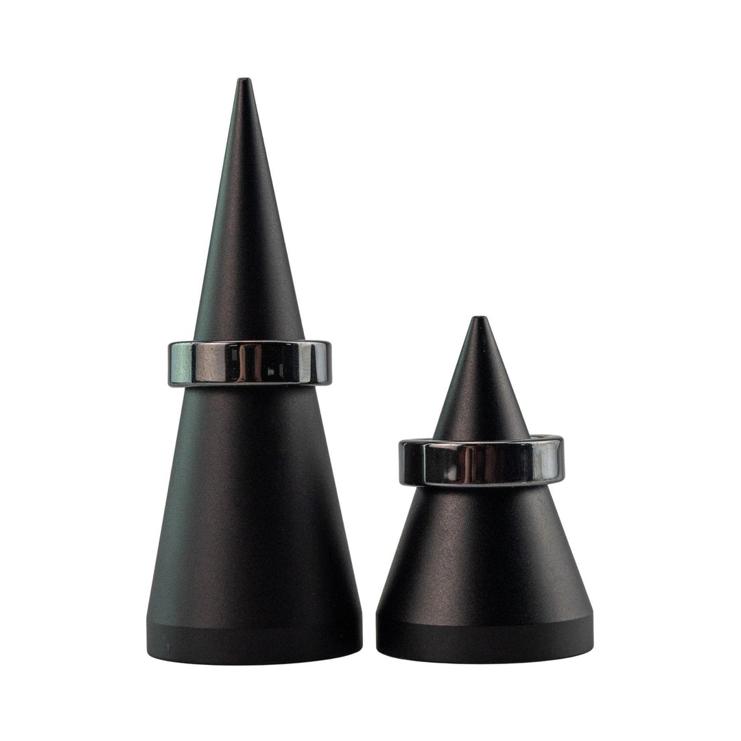 "Two Hematite Rings on conical objects on a white background," - Up N Smoke.