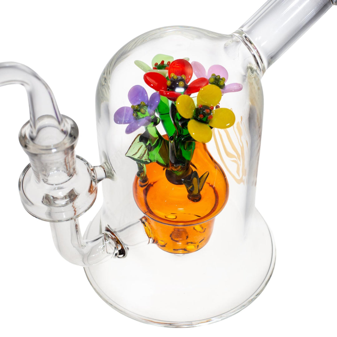 "A studio photograph of the insides of a Pulsar Summer Flowers dab rig. It features a potted flower inside the functional glass piece." - Up N Smoke.